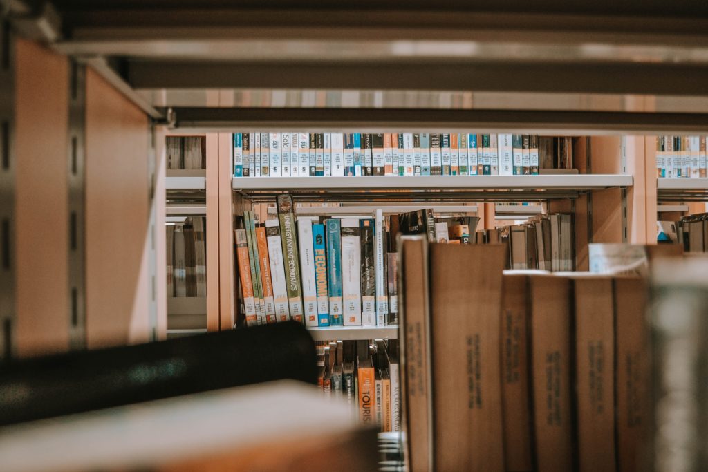 Metal shelves are lined with books in the university library.